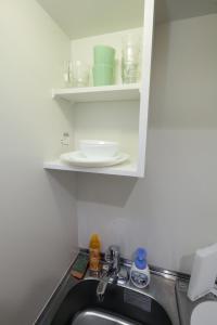 eine Küchenspüle mit einem Regal über der Spüle in der Unterkunft Nano Kita Shinjuku / Vacation STAY 62654 in Tokio