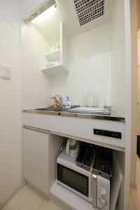 eine Küche mit einer Spüle und einer Mikrowelle in der Unterkunft Nano Kita Shinjuku / Vacation STAY 62654 in Tokio