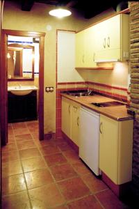 a kitchen with white cabinets and a sink in it at Los Masecicos in Mora de Rubielos