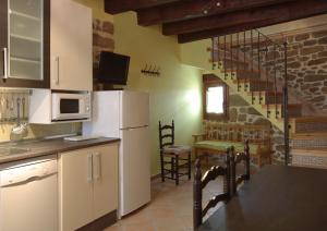 a kitchen with a white refrigerator and a staircase at Los Masecicos in Mora de Rubielos