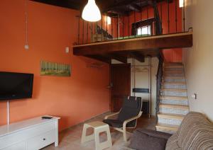 a living room with a staircase and a couch and a television at Los Masecicos in Mora de Rubielos