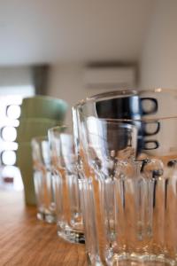 a row of empty glasses sitting on a wooden table at Apartment Hotel Tenjin TUMUGU / Vacation STAY 62166 in Susakiuramachi