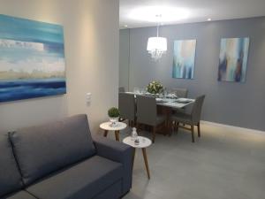 sala de estar con sofá y mesa de comedor en Mariscal 02 dormitórios, 80m do mar, com piscina, en Bombinhas