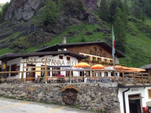 un edificio con sombrillas frente a una montaña en Rifugio Capanna Bill, en Rocca Pietore