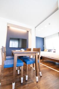 - une salle à manger avec une table, des chaises et un lit dans l'établissement Apartment Hotel Tenjin TUMUGU / Vacation STAY 62175, à Susakiuramachi