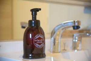 une bouteille de savon posée sur un lavabo de salle de bain dans l'établissement Apartment Hotel Tenjin TUMUGU / Vacation STAY 62175, à Susakiuramachi 68 autres photos