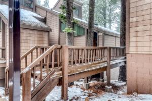 une terrasse en bois devant une maison dans la neige dans l'établissement Northstar Condo in the Trees, à Truckee
