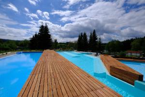a large swimming pool with a wooden deck at Lipno-Frymburk Wellnes APT D 103 in Frymburk