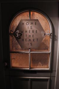 une fenêtre avec une horloge qui lit à la maison où se trouve le cœur dans l'établissement Ferienwohnung Bruno, à Gnesau