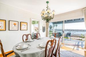 a dining room with a table and chairs and a large window at La Playa Abode in San Diego