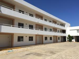 a large white apartment building with a parking lot at Hotel Villa Campeche in Campeche