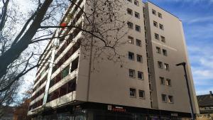 un alto edificio bianco di fronte a un albero di Your2ndhome-3 a Sindelfingen