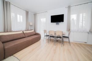 a living room with a couch and a table and chairs at Apartament z dużym balkonem Osiedle Zwycięzców in Polanica-Zdrój