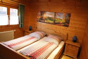 a bedroom with two beds in a log cabin at Romantikhütten 1 & 24 in Stamsried