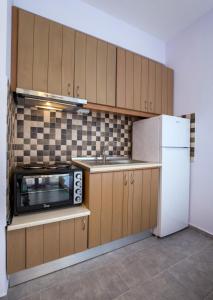 Una cocina con un refrigerador blanco y un microondas. en Studios Koula 2 -MARY, en Potos 24 fotos más