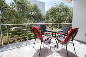 una mesa y sillas en un balcón con árboles en Studios Koula 2 -MARY, en Potos