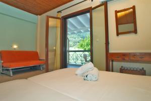 a bedroom with a bed and a chair and a window at Vicky Apartments in Nikiana +101 photos