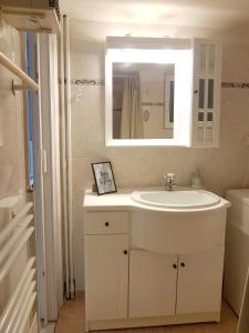 een witte badkamer met een wastafel en een spiegel bij Colourful Apartment in the heart of Athens in Athene