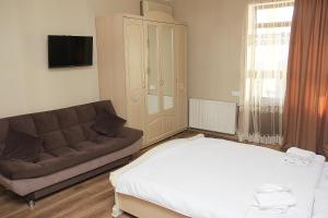 Boutique Hotel Dany في تبليسي: غرفة معيشة مع سرير وأريكة