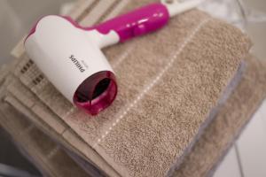 a pink and white toothbrush sitting on top of a towel at Svajonių apartamentai in Druskininkai