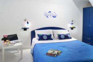 ein blau-weißes Schlafzimmer mit einem Bett und einem Schreibtisch in der Unterkunft Casa Amore Amalfi in Amalfi