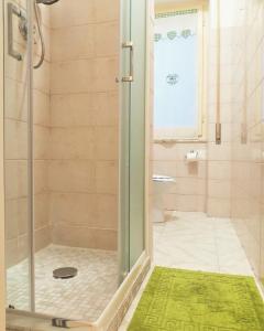 een douche met een glazen deur in de badkamer bij Molly & Luna in Cagliari