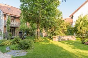 a yard of a house with a tree and grass at Hôtel la Croix Blanche in Posieux