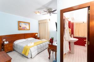 a bedroom with a bed and a bathroom with a sink at Hotel Marini in Sassari