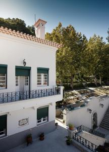 Edificio blanco con balcón y río en Casa do Comendador en Manteigas