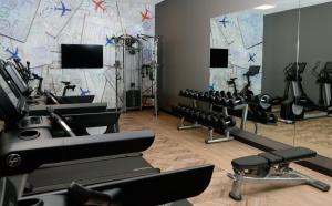 a gym with rows of exercise equipment and mirrors at Hyatt Place Pena Station/Denver Airport in Denver