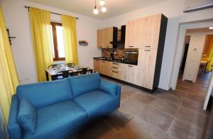 a living room with a blue couch and a kitchen at La casetta di Anastasia in Rome
