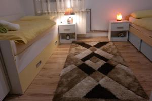een slaapkamer met 2 bedden en een tapijt bij Gorski cvijet in Delnice