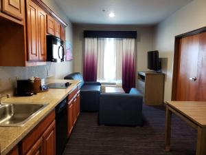 uma cozinha com um lavatório e uma sala de estar em Best Western Plus San Antonio East Inn & Suites em San Antonio