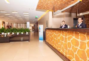 a man and a woman sitting at a counter in a lobby at Best Western Hotel Goldenmile Milan in Trezzano sul Naviglio +63 photos