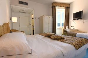 a hotel room with two beds and a television at Best Western Hotel Acqua Novella in Spotorno