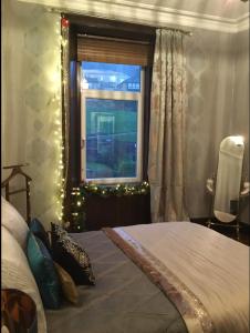 ポート・グラスゴーにあるVictorian flatのベッドルーム1室(ベッド1台付)、クリスマスライト付きの窓が備わります。