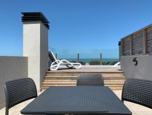 a table and chairs on top of a patio at Casiopea Apart-Spa-Mar in Mar de las Pampas