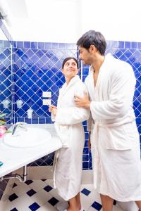 um homem e uma mulher de pé numa casa de banho em Hotel Marini em Sassari