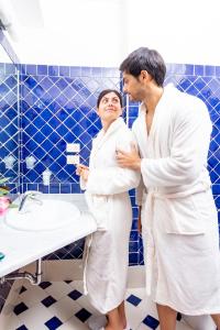 a man and a woman standing in a bathroom at Hotel Marini in Sassari