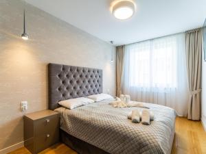 a bedroom with a bed with two stuffed animals on it at Apart111 Apartamenty - Platinum in Kołobrzeg