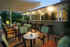 un ristorante all'aperto con tavoli, sedie e ombrellone di Vicky Apartments a Nikiana