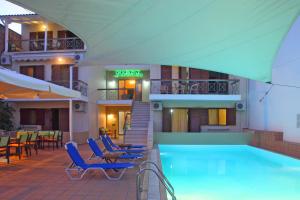 un hotel con piscina con sedie e tavoli di Vicky Apartments a Nikiana