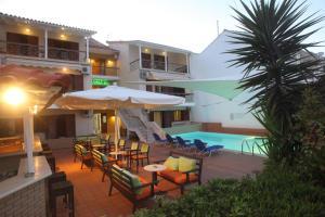 a hotel patio with tables and chairs and a pool at Vicky Apartments in Nikiana
