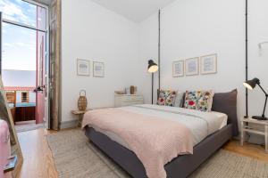 a bedroom with a bed and a large window at aleixomor'Aqui in Loulé