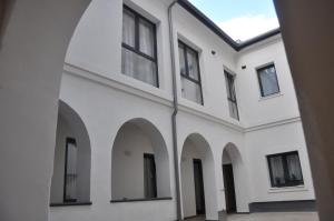 an external view of a white building with arches at Centrál Vendégház Székesfehérvár in Székesfehérvár