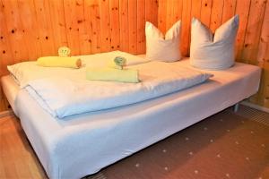 a large bed with white sheets and pillows on it at Haus Grassa in Brand