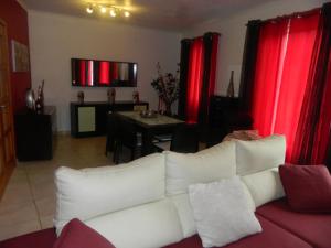 salon z białą kanapą i czerwonymi zasłonami w obiekcie Casa da Piedade w mieście Piedade