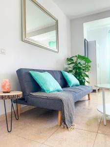 a blue couch in a living room with a mirror at Hibiscus Studio in Corralejo