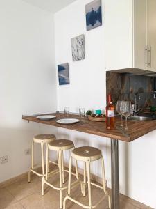a kitchen with a island with stools and a counter top at Hibiscus Studio in Corralejo