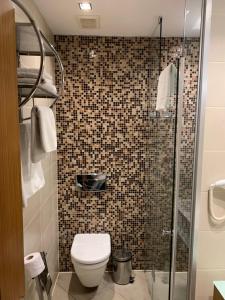 a bathroom with a toilet and a glass shower at City Hotel Plovdiv in Plovdiv